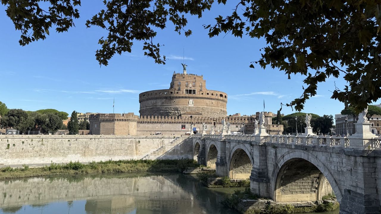 Castel Sant'Angelo and Ponte Sant'Angelo seen from the Tiber bank, plane trees overhead