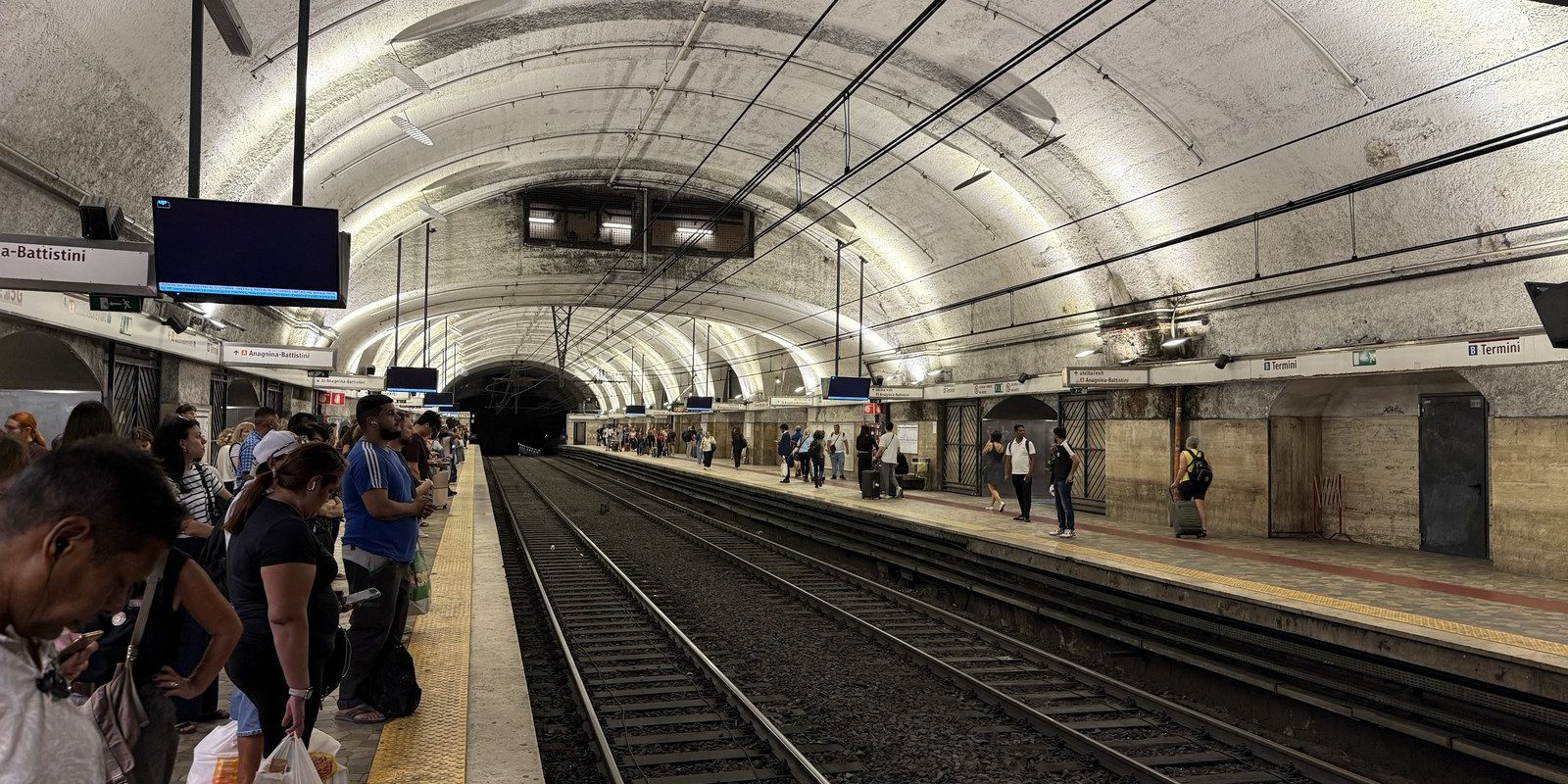 The metro platform at Roma Termini, crowds waiting close together on both sides of the tracks